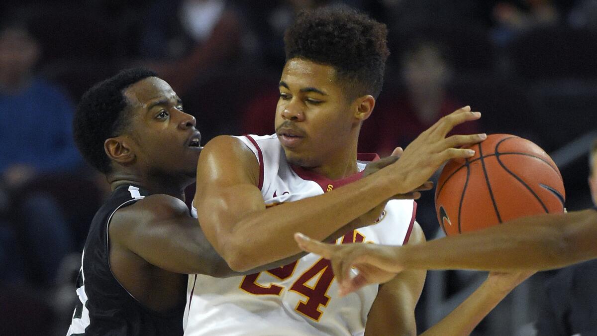 Portland State guard DaShaun Wiggins, left, tries to hit the ball away from USC guard Malik Marquetti during the Trojans' 76-68 loss Saturday.