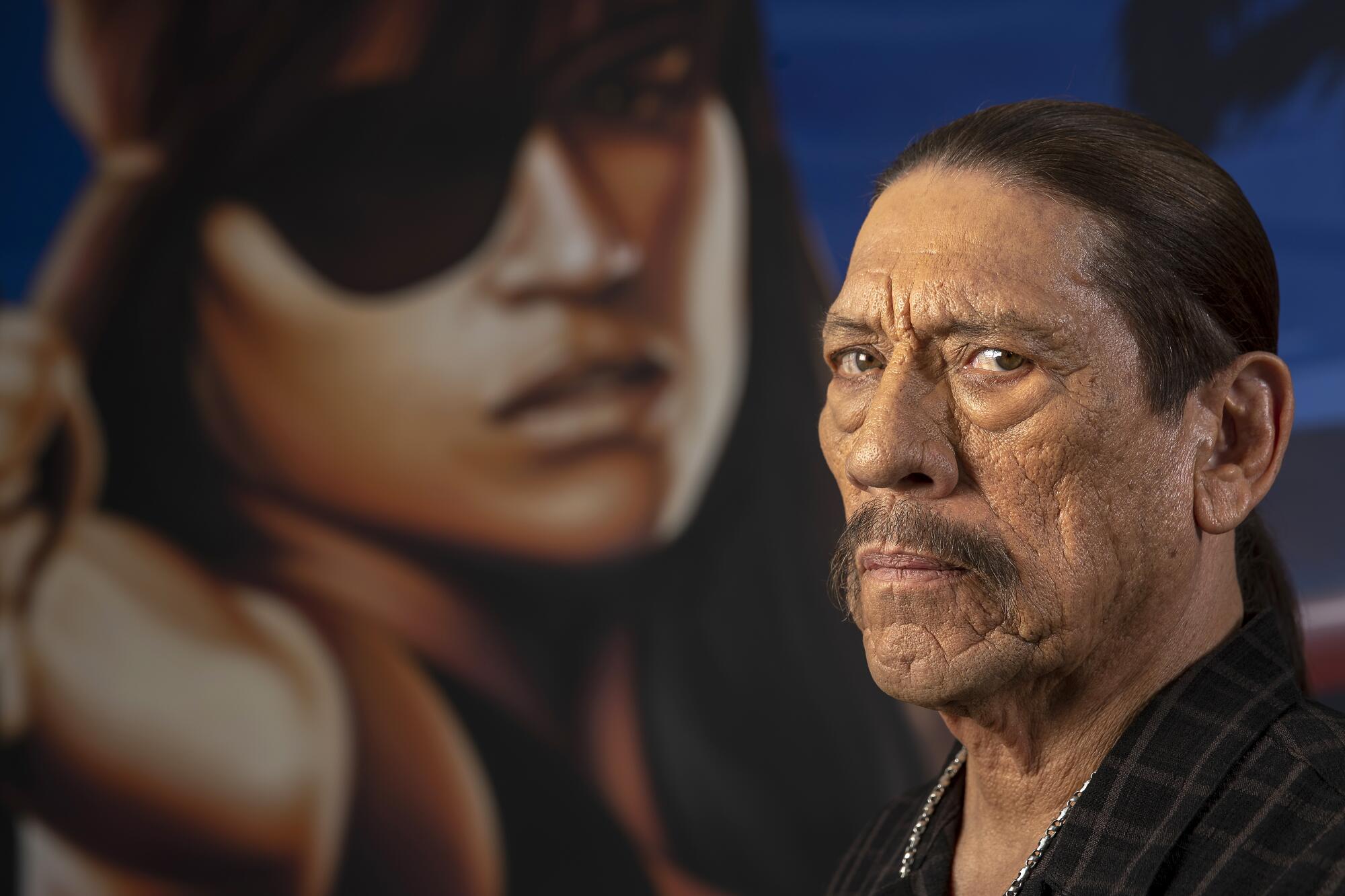 Danny Trejo in front of an image of a person with a black eye patch