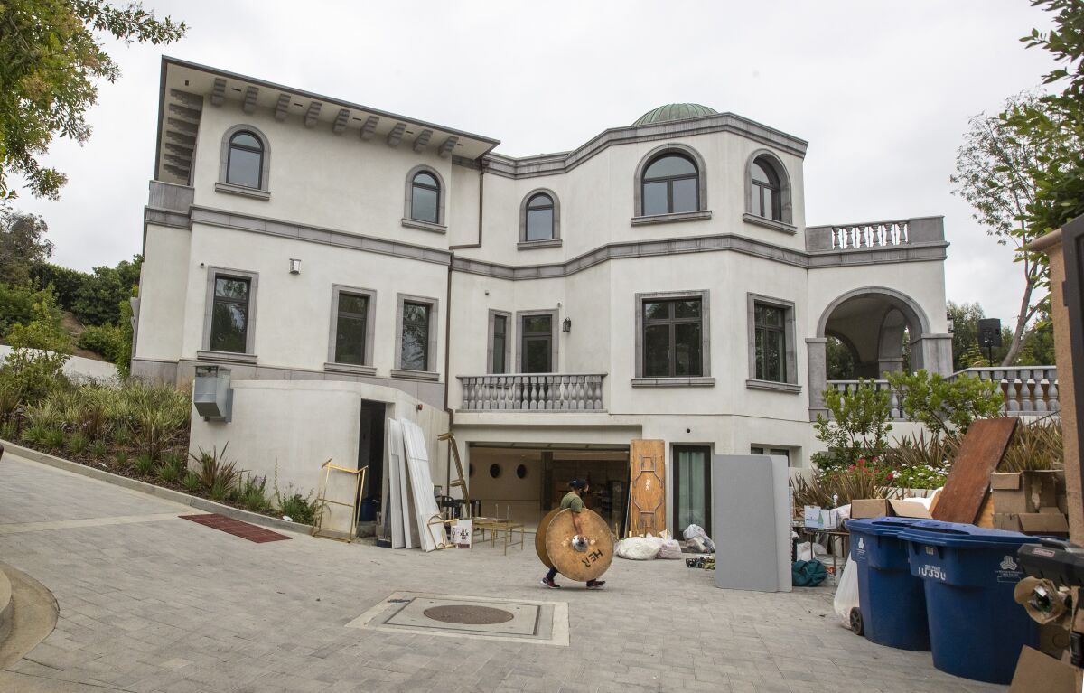 Party rental crews pack up at a home in the 10000 block of Wyton Drive in Holmby Hills