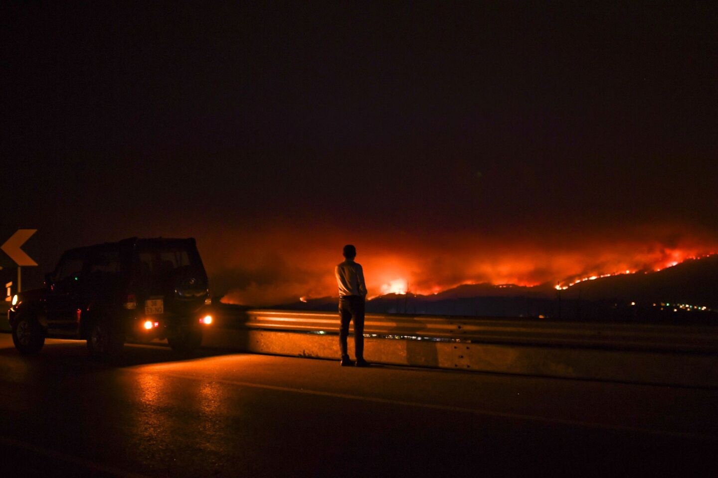 A man watches a wildfire Sunday at Anciao, Leiria, in central Portugal.