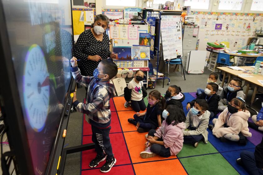 FILE - Kindergarten teacher Ana Zavala, at left, instructs students amid the COVID-19 pandemic at Washington Elementary School on Jan. 12, 2022, in Lynwood, Calif. California will not expand education to make kindergarten mandatory after Gov. Gavin Newsom vetoed a law meant to address decreasing attendance during the pandemic. The bill Newsom vetoed Sunday, Sept. 25, 2022, aimed to close the gap in academic opportunity for low-income students and students of color. (AP Photo/Marcio Jose Sanchez, File)