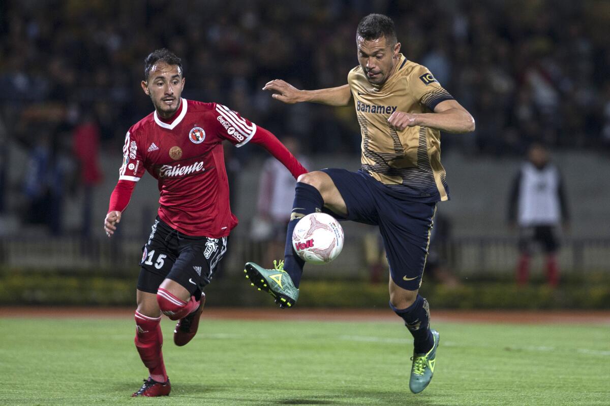 Tijuana defender Carlos Guzman, left, pressures Pumas forward Dante Lopez during a Liga MX match on April 22.