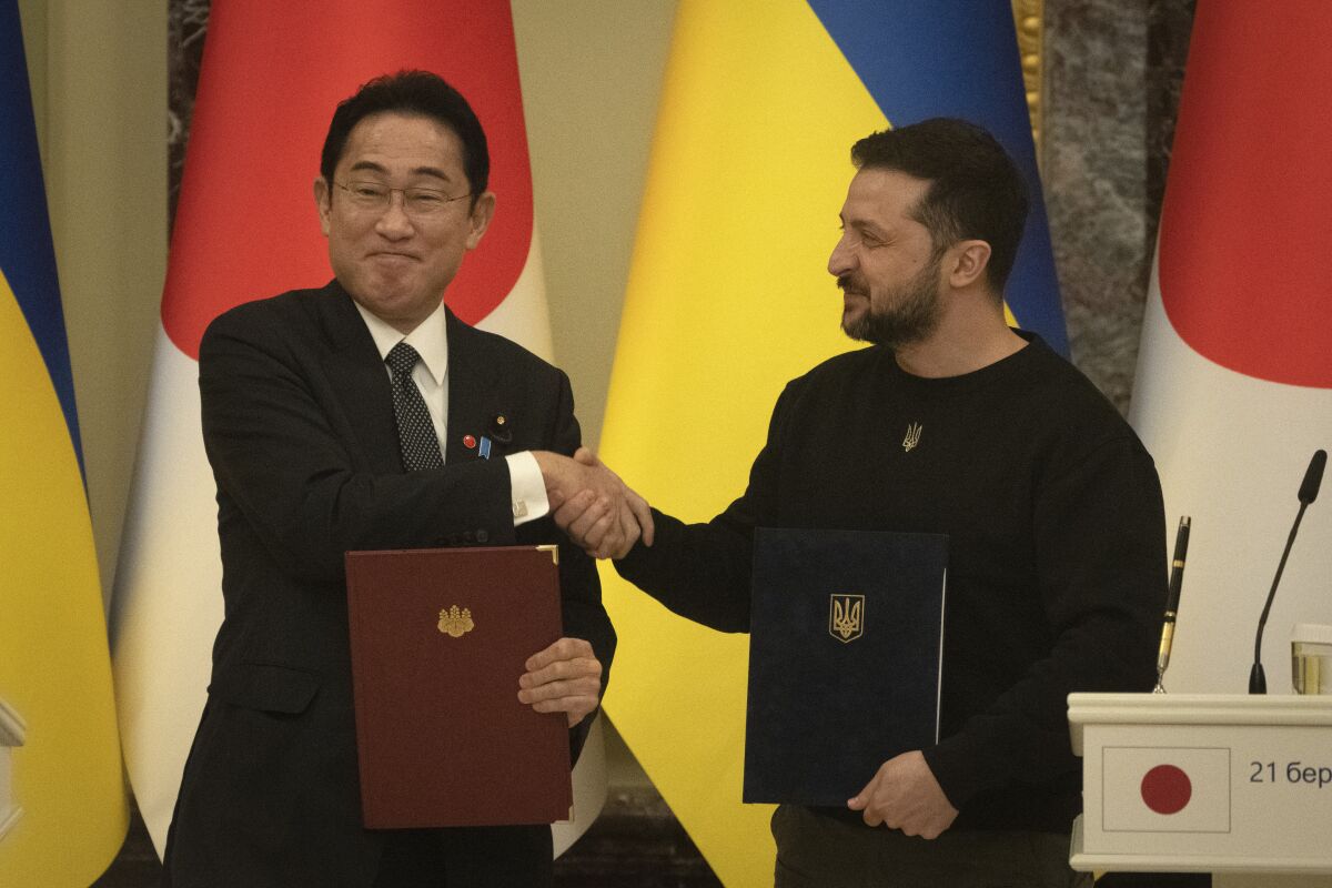 Japanese Prime Minister Fumio Kishida and Ukrainian President Volodymyr Zelenskyy, right, greet each other after the signing of joint documents in Kyiv, Ukraine, Tuesday, March 21, 2023. (AP Photo/Efrem Lukatsky)