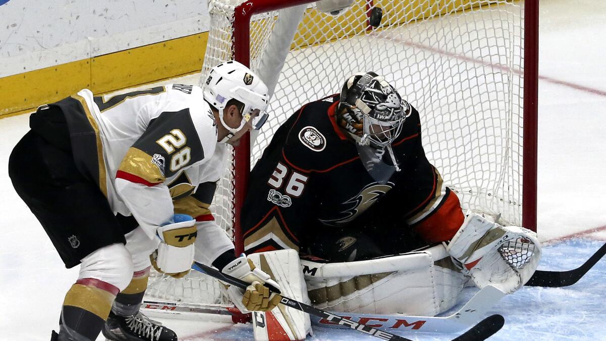 Ducks goalie John Gibson deflects the puck as Vegas Golden Knights left winger William Carrier (28) looks for the rebound during the first period Wednesday.