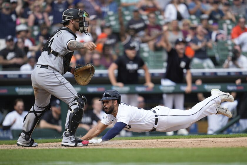 Detroit Tigers' Riley Greene slides safely into home plate to score as Chicago White Sox catcher Yasmani Grandal (24) waits for the throw in the ninth inning of a baseball game, Sunday, May 28, 2023, in Detroit. (AP Photo/Paul Sancya)