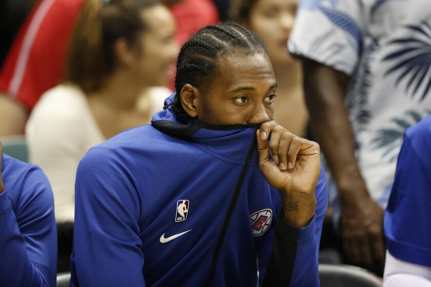 Los Angeles Clippers small forward Kawhi Leonard (2) sits on the bench during an NBA preseason basketball game against the Houston Rockets, Thursday, Oct 3, 2019, in Honolulu. (AP Photo/Marco Garcia)