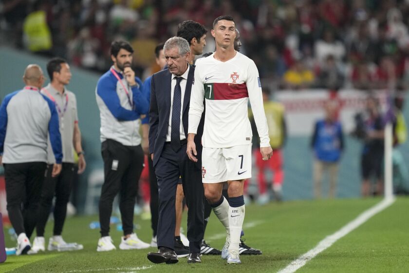Portugal's Cristiano Ronaldo, center, passes beside his coach Fernando Santos as he leaves the field during the World Cup group H soccer match between South Korea and Portugal, at the Education City Stadium in Al Rayyan , Qatar, Friday, Dec. 2, 2022. (AP Photo/Lee Jin-man)