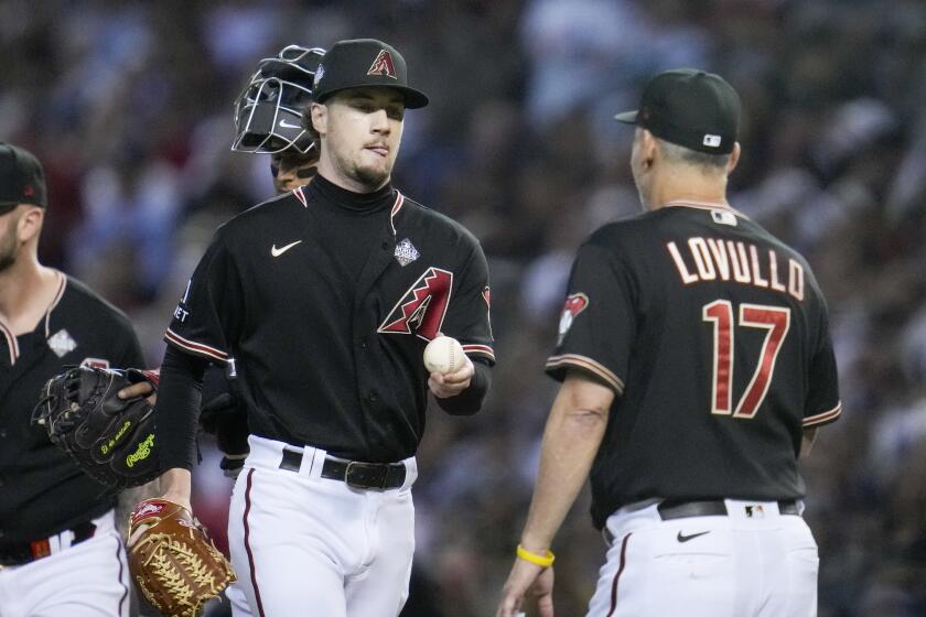Arizona Diamondbacks relief pitcher Kyle Nelson is pulled from the game by manager Torey Lovullo during the third inning in Game 4 of the baseball World Series against the Texas Rangers Tuesday, Oct. 31, 2023, in Phoenix. (AP Photo/Godofredo A. Vásquez)