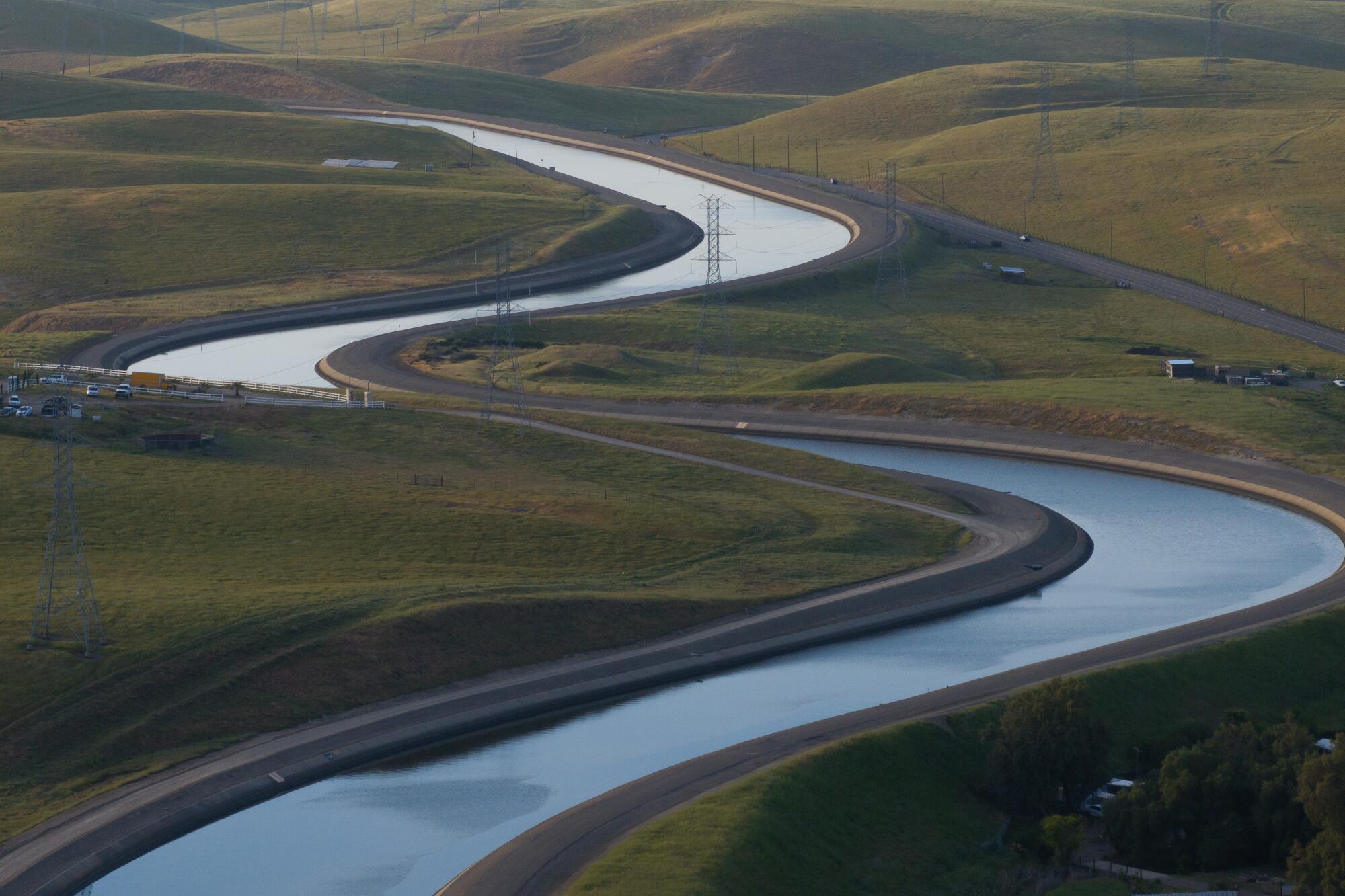 The California Aqueduct meanders through green fields.
