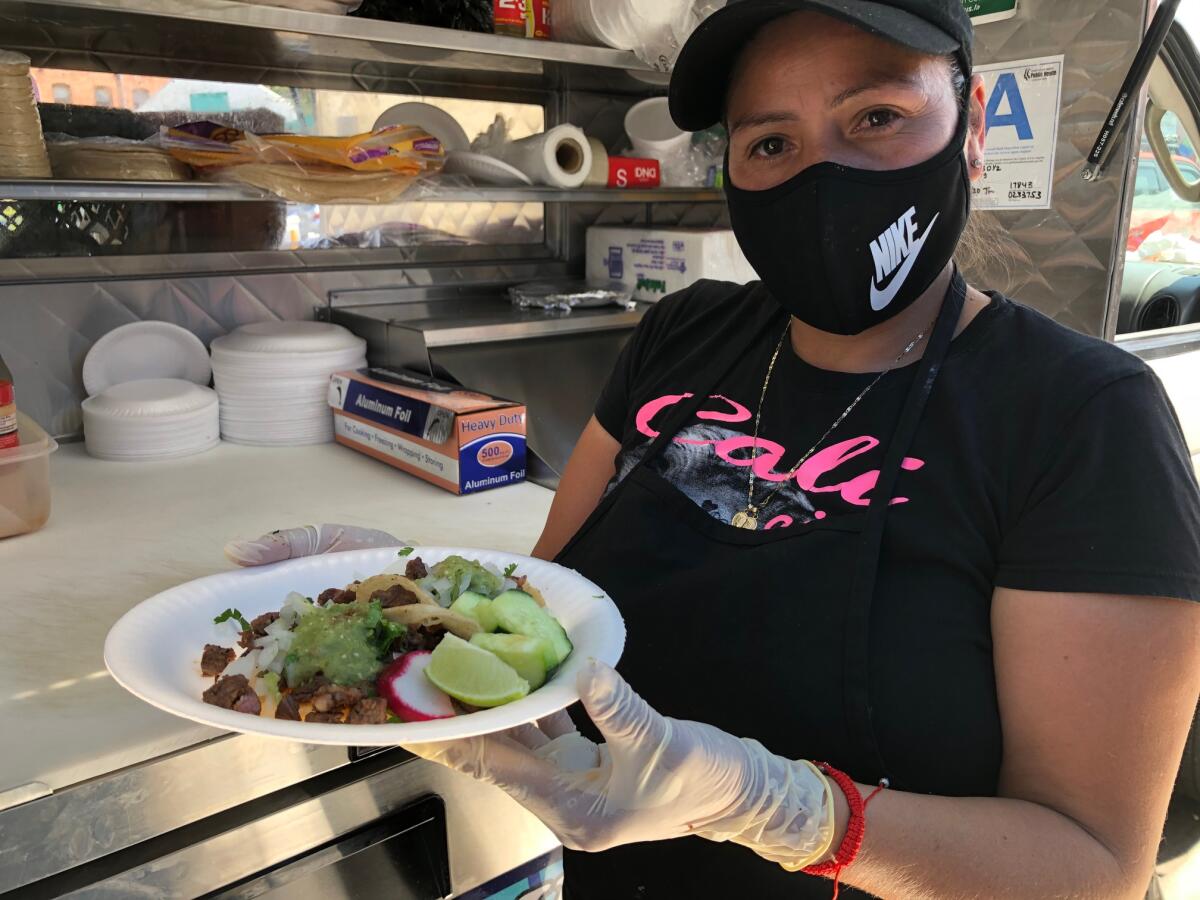 La empresaria Carmen Calles muestra una orden de tacos que fue preparada en su camión de comida.