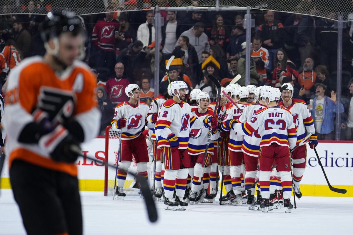 New Jersey Devils' players celebrate after an NHL hockey game against the Philadelphia Flyers, Saturday, Dec. 3, 2022, in Philadelphia. (AP Photo/Matt Slocum)