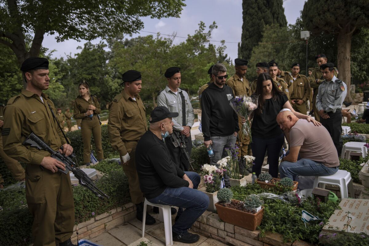 Israeli soldiers and family members of fallen soldiers gather for a ceremony marking Israel's annual Memorial Day at a military cemetery in Tel Aviv, Israel, Wednesday, May 4, 2022. Israel marks Memorial Day in remembrance of soldiers who died in the nation's conflicts. (AP Photo/Oded Balilty)