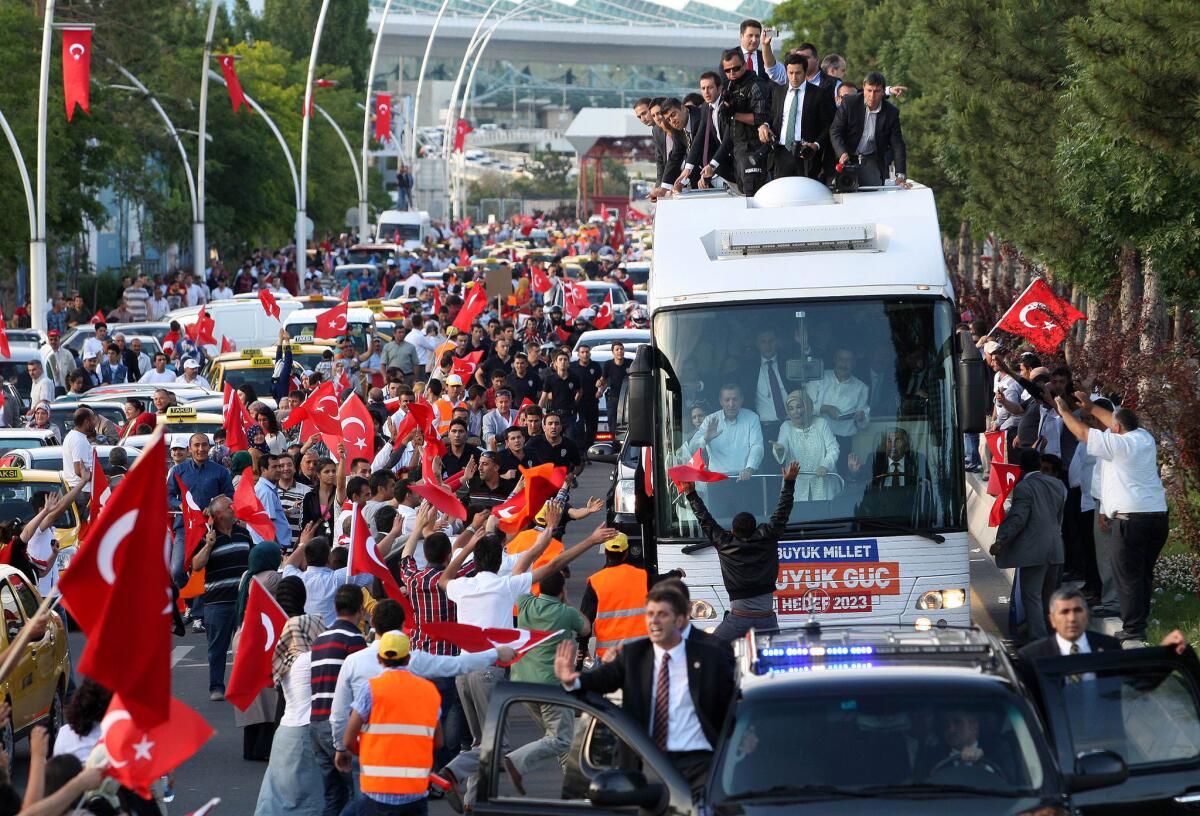 Turkish Prime Minister Recep Tayyip Erdogan (at left in bus) and his wife Emine wave to supporters on their arrival in Ankara on Sunday. Erdogan warned today that the patience of his Islamic-rooted government "has a limit" as mass protests against his decade-long rule raged for a 10th day.