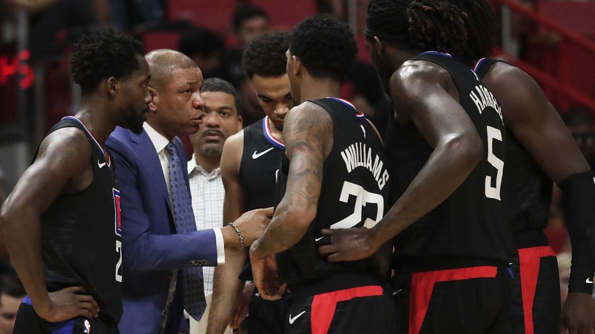 Coach Doc Rivers huddles with his players during a timeout Wednesday night in Miami.