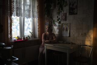 Natalia Rosolova poses for a portrait inside her house in Kupiansk-Vuzlovyi, Ukraine, Wednesday, Aug. 23, 2023. Residents of the war-ravaged settlement close to the northeast frontline are ignoring calls from Ukrainian authorities to evacuate as the fighting inches closer. (AP Photo/Bram Janssen)