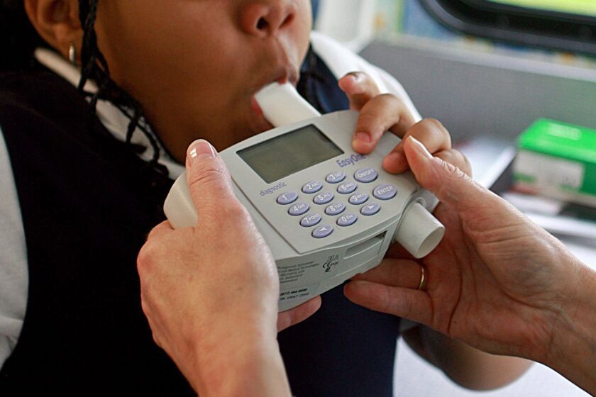 FILE - An 8-year-old student blows into a spirometer held by a nurse outside an elementary school in Bel Nor, Mo., in May 2009. Racial bias built into a common medical test for lung function is likely leading to fewer Black patients getting care for breathing problems, researchers said in a study published in JAMA Network Open on Thursday, June 1, 2023. (Christian Gooden/St. Louis Post-Dispatch via AP, File)