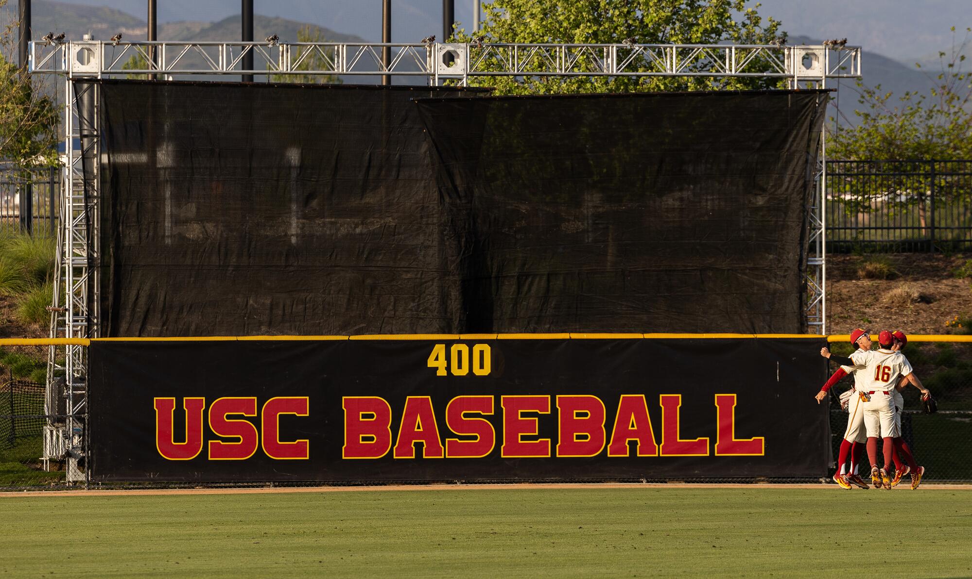 USC outfielders celebrate next to the batter's eye that was built for USC at the Great Park in Irvine on May 3.