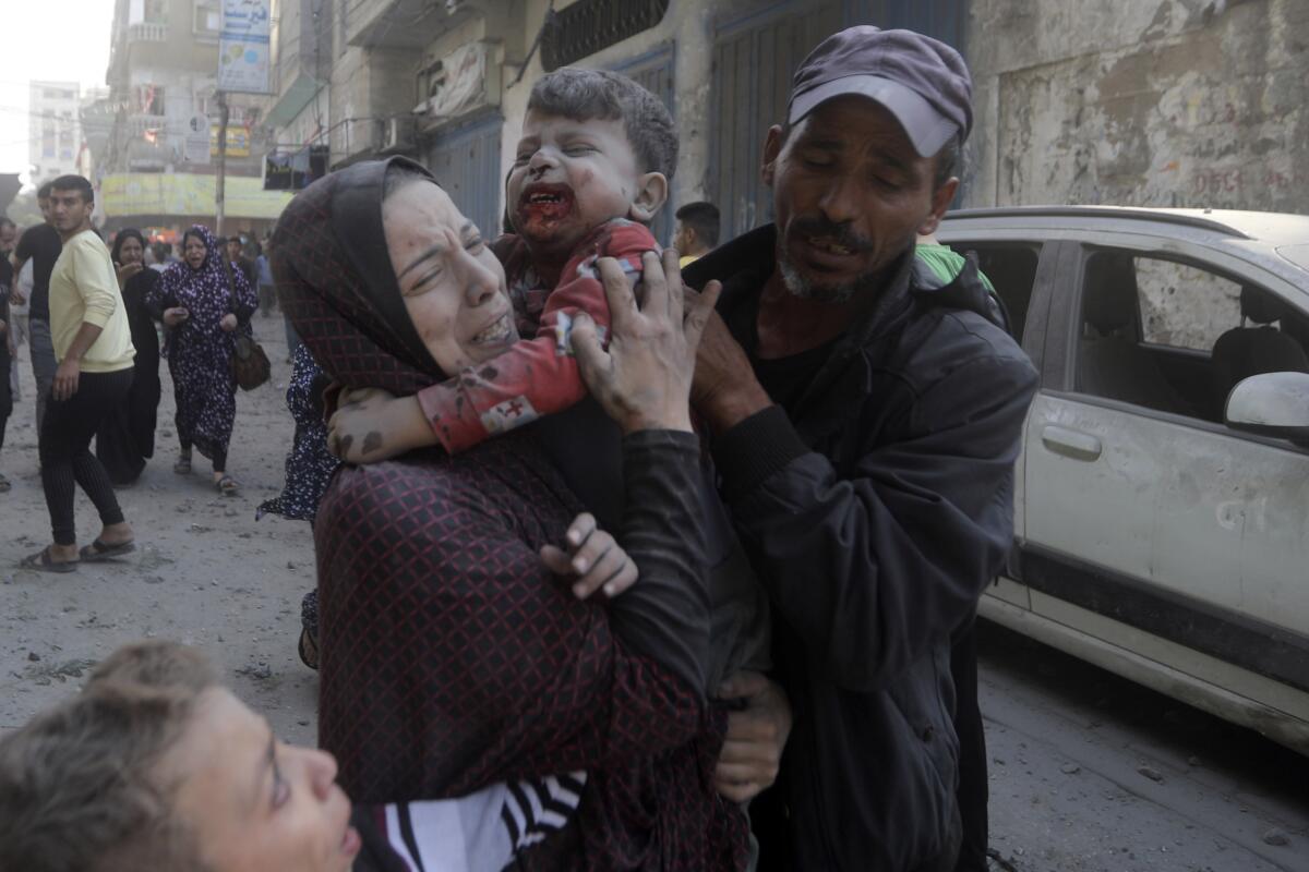 Una palestina llora mientras carga a su hijo herido tras un ataque aéreo israelí 