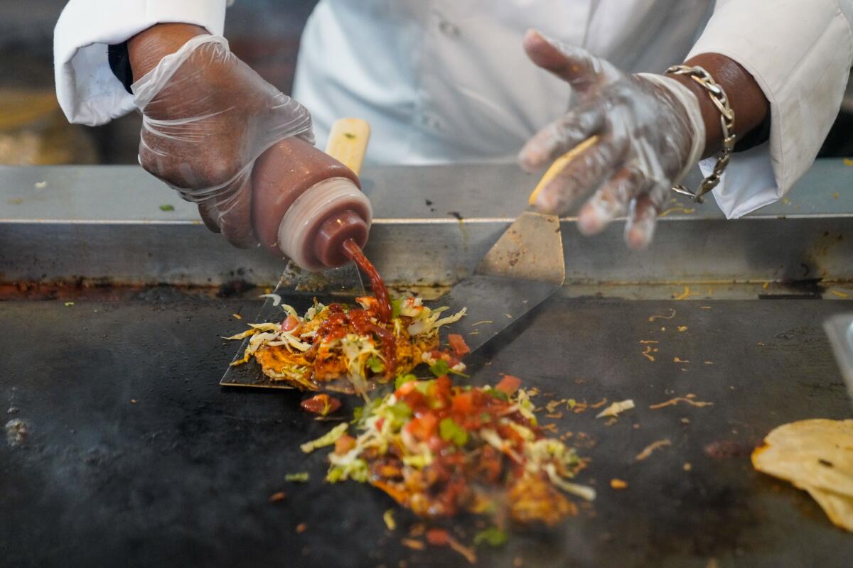Barbara "Sky" Burrell, owner and chef of Sky's Gourmet Tacos, preparing shrimp tacos at her restaurant.