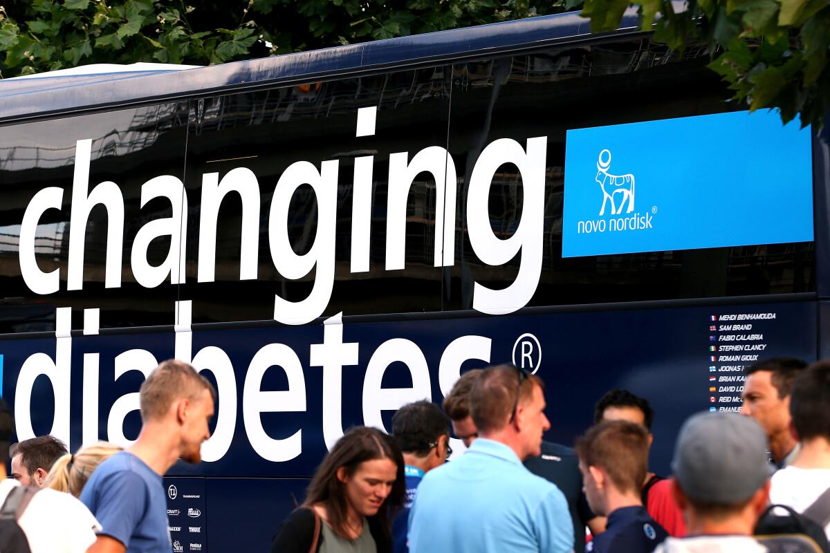 People stand around a bus that bears the words "Changing Diabetes."