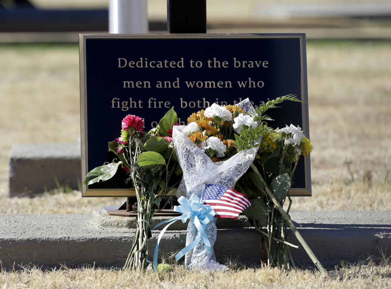 Flowers are seen at a plaque honoring ground and air firefighters at the California Department of Forestry and Fire Protection Aviation Management facility at McClellan Air Park in Sacramento. Air tanker pilot Geoffrey "Craig" Hunt was killed Tuesday while fighting the Dog Rock Fire.