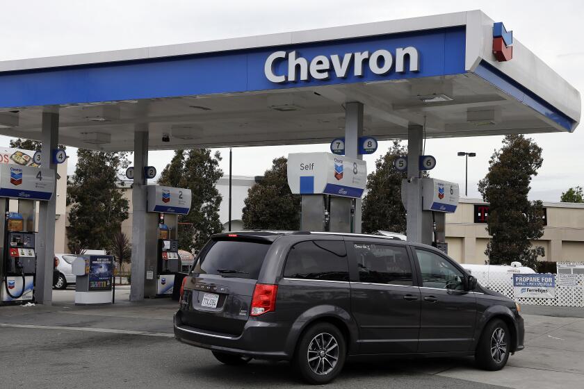 FILE - A motorist drives near the pumps at a Chevron gas station in Oakland, Calif. Tuesday, April 25, 2017. California jury has returned a $63 million verdict against Chevron after finding the oil giant covered up a toxic chemical pit and then sold the land to a man who built a house on it and was later diagnosed with a blood cancer. (AP Photo/Ben Margot, File)