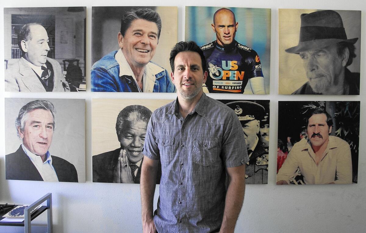 Co-founder Mike Lastrina shows images printed on wood of some of his favorite celebrities at the Woodsnap headquarters in Irvine.