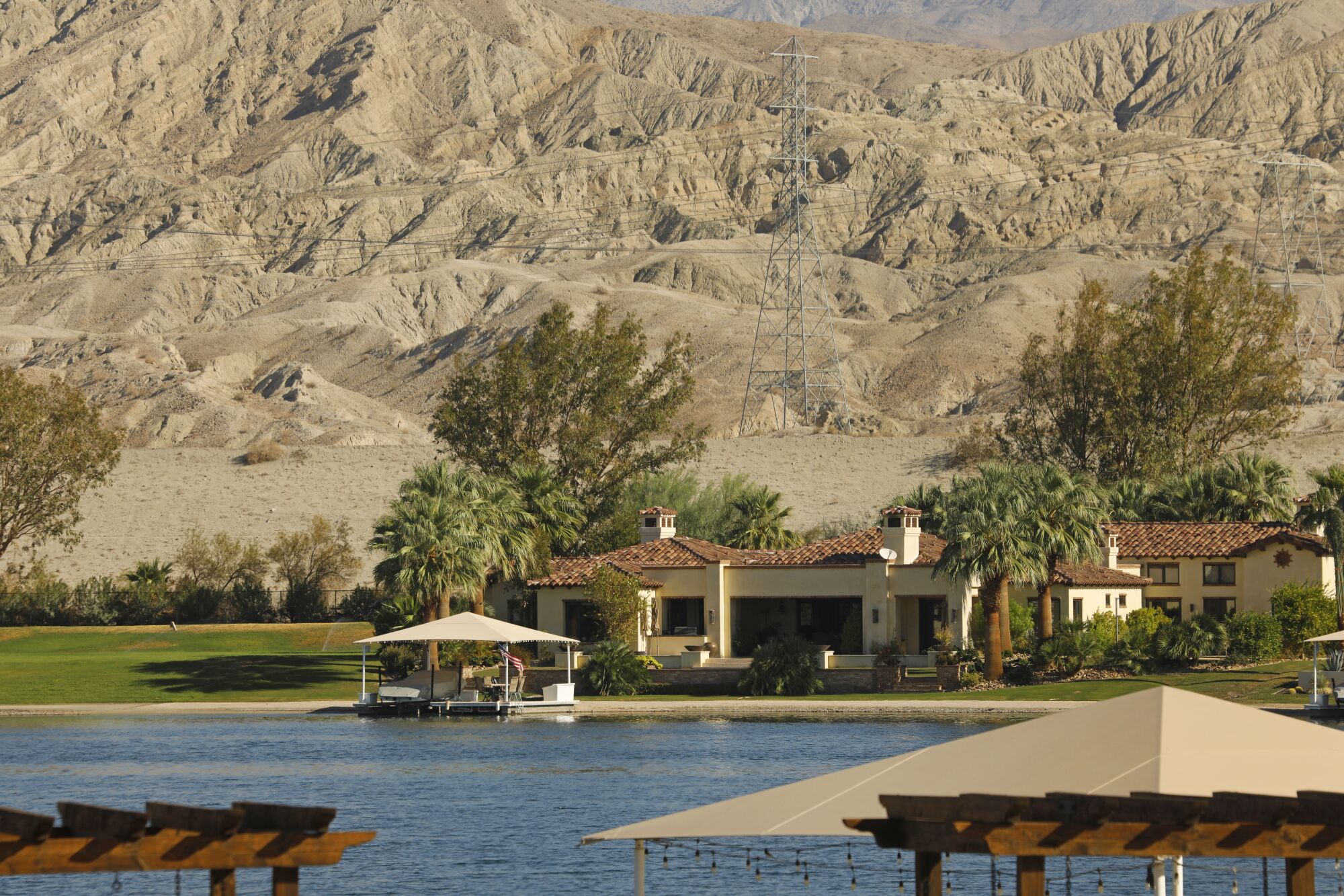 Houses by an artificial lake next to desert mountains.