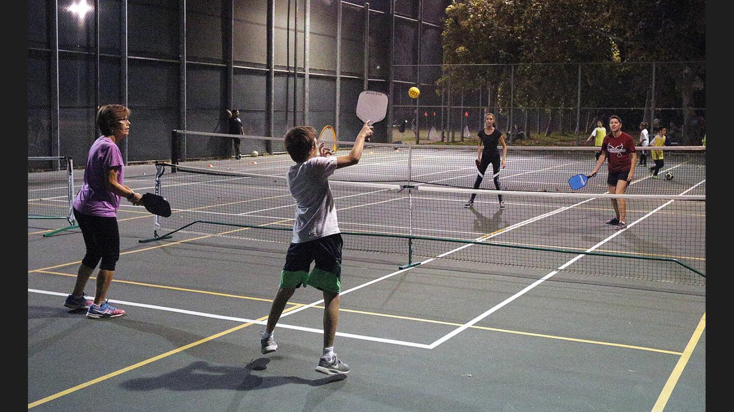 Janet Beardsley, Dominic Salvatore, Alyssa Phelps, and Amy Phelps, play a pick-up pickleball game on the tennis court at Larry Maxam Park on Tuesday, October 17, 2017. Local pickleball enthusiasts are hoping to have the courts converted into full-time pickleball courts.