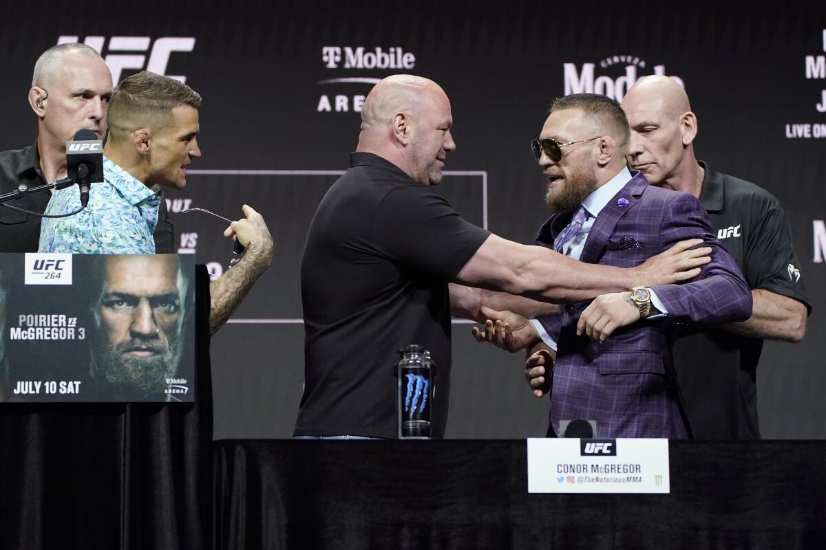 Dana White, center, UFC President, holds Conor McGregor away from Dustin Poirier 