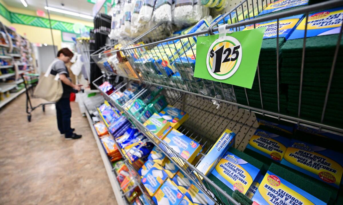 A woman stands while looking at items on shelves in a store.