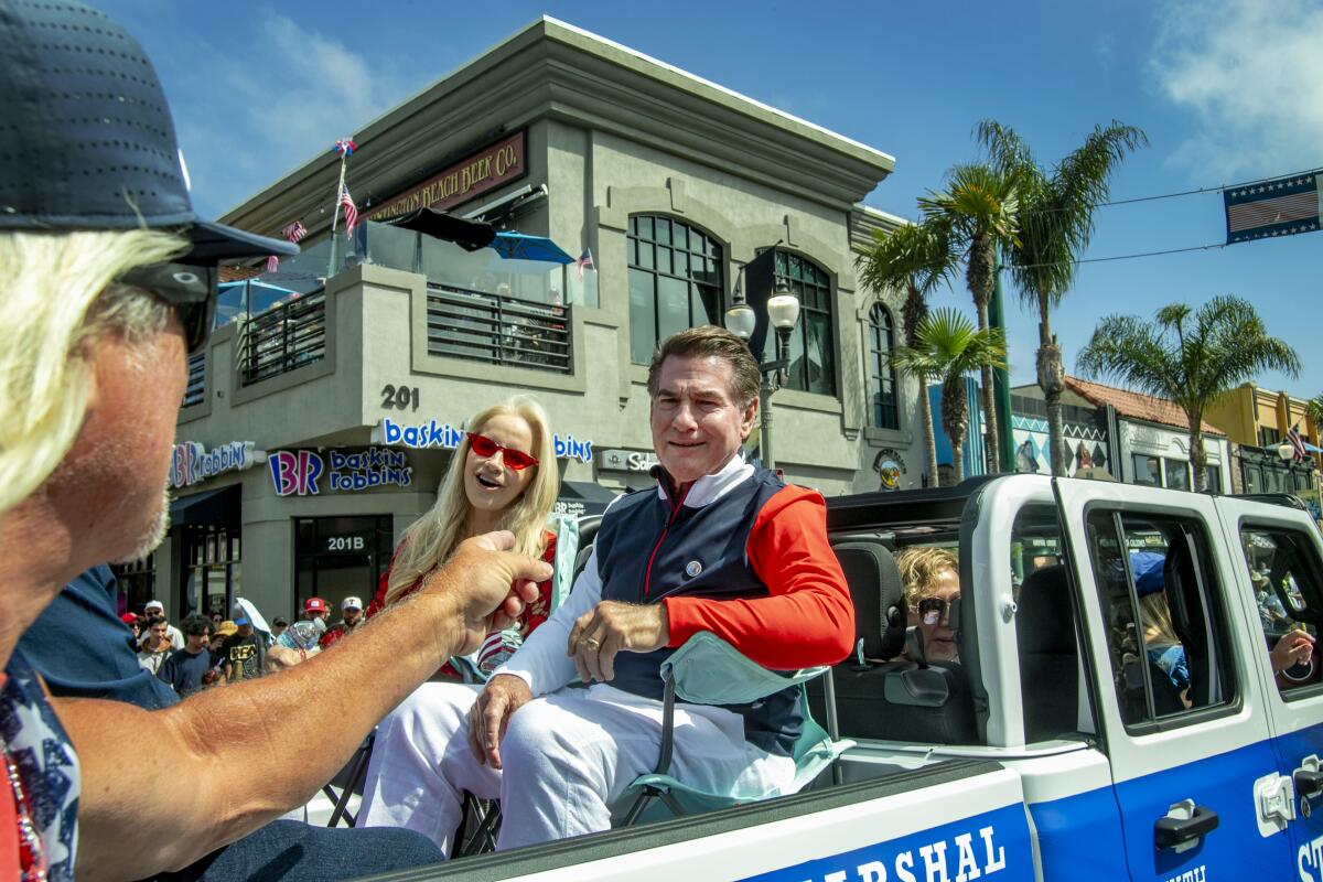 Huntington Beach Fourth of July Parade grand marshal Steve Garvey and daughter Candace meet an admirer on Main Street.