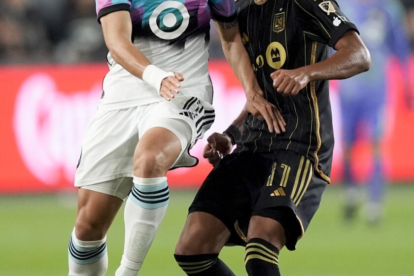 Minnesota United forward Jeong Sang-Bin, left, and Los Angeles FC midfielder Timothy Tillman vie for the ball during the second half of an MLS soccer match Wednesday, May 29, 2024, in Los Angeles. (AP Photo/Ryan Sun)