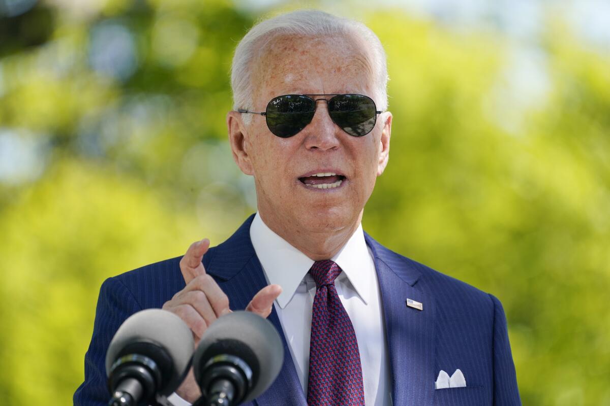President Biden, in sunglasses, answers a question 