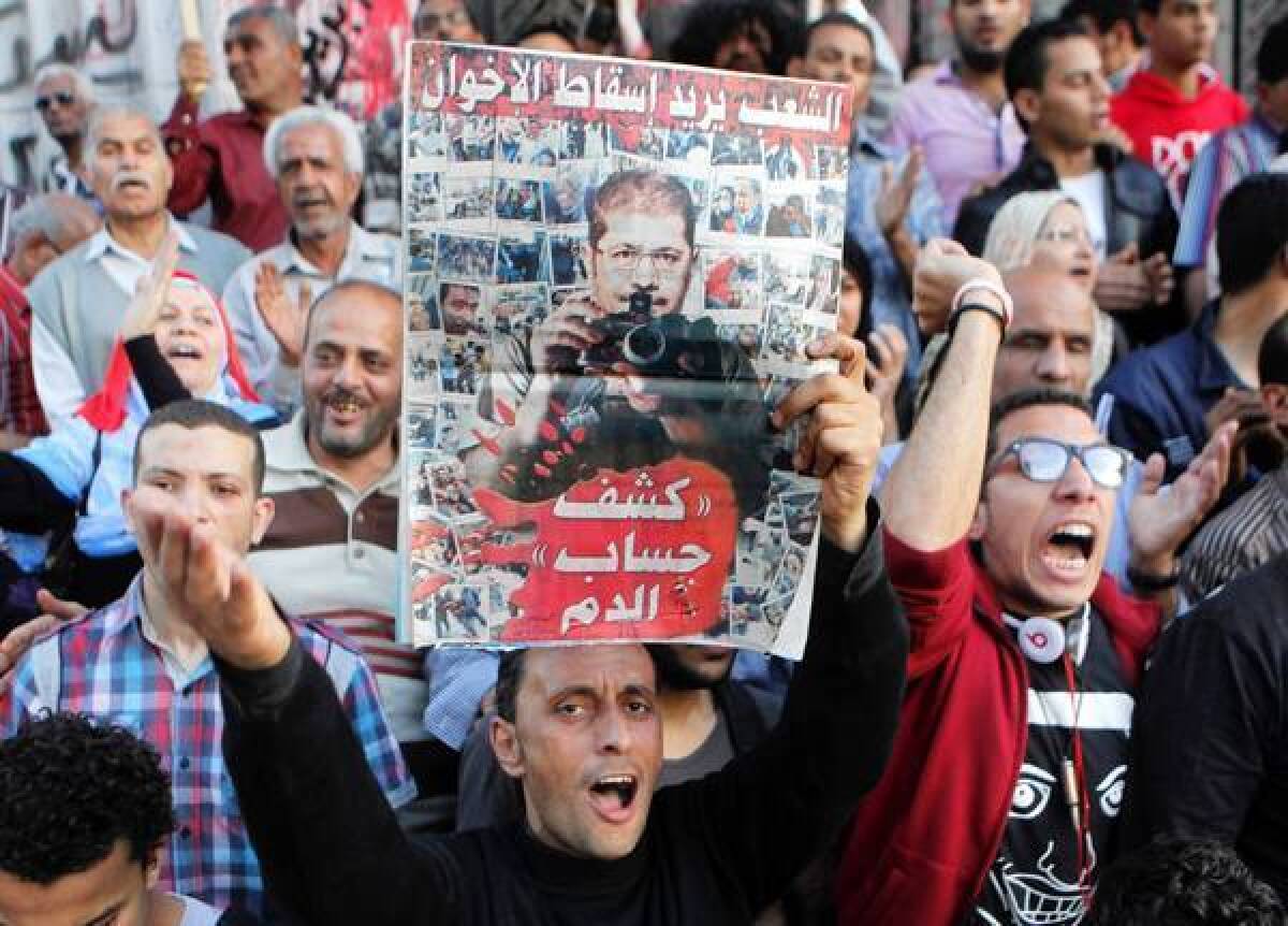 Members of Egypt's April 6 Youth Movement shout slogans against the Muslim Brotherhood and raise a poster criticizing President Mohamed Morsi at a recent rally in Cairo.