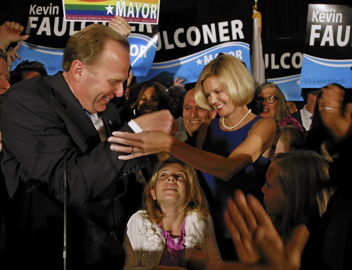 San Diego mayoral candidate Kevin Faulconer reaches for his wife, Katherine, as their daughter looks up from below after Faulconer addressed his supporters at a rally Tuesday, Feb. 11, 2014, in San Diego. (AP Photo/Lenny Ignelzi) ** Usable by LA and DC Only **