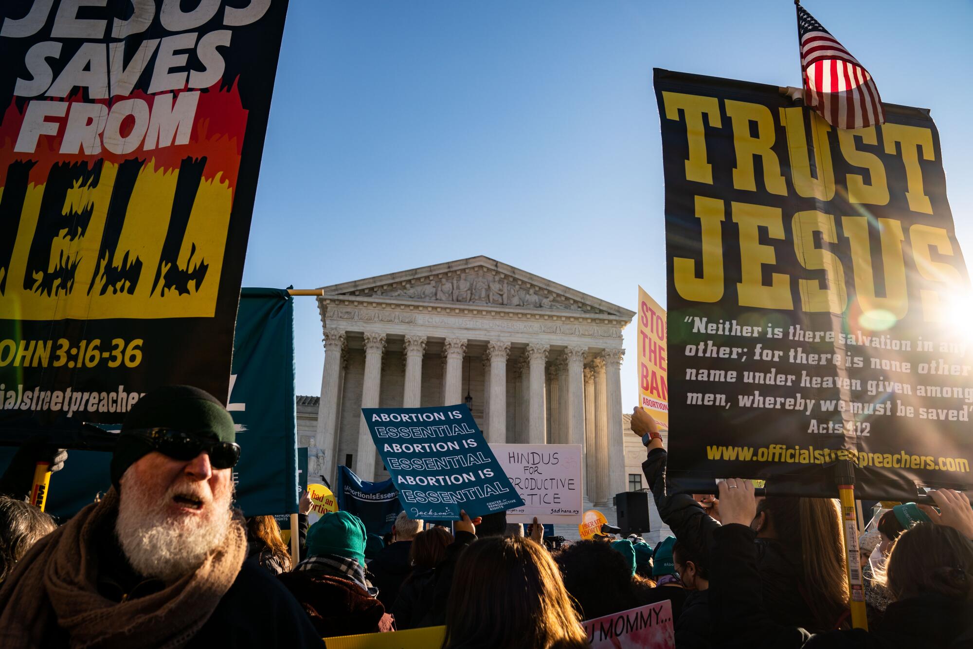 Abortion rights advocates and anti-abortion protesters demonstrate with signs in front of the Supreme Court building