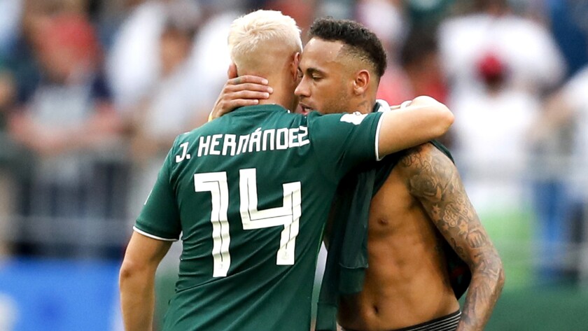 Mexico's Javier Hernandez (14) embraces Brazil's Neymar after their round of 16 game Monday.