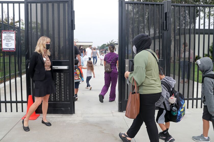 Principal Jill Van Der Linden, left, welcomes parents and students back to campus for the first day of instruction at Lake View Elementary School on Wednesday morning in Huntington Beach.