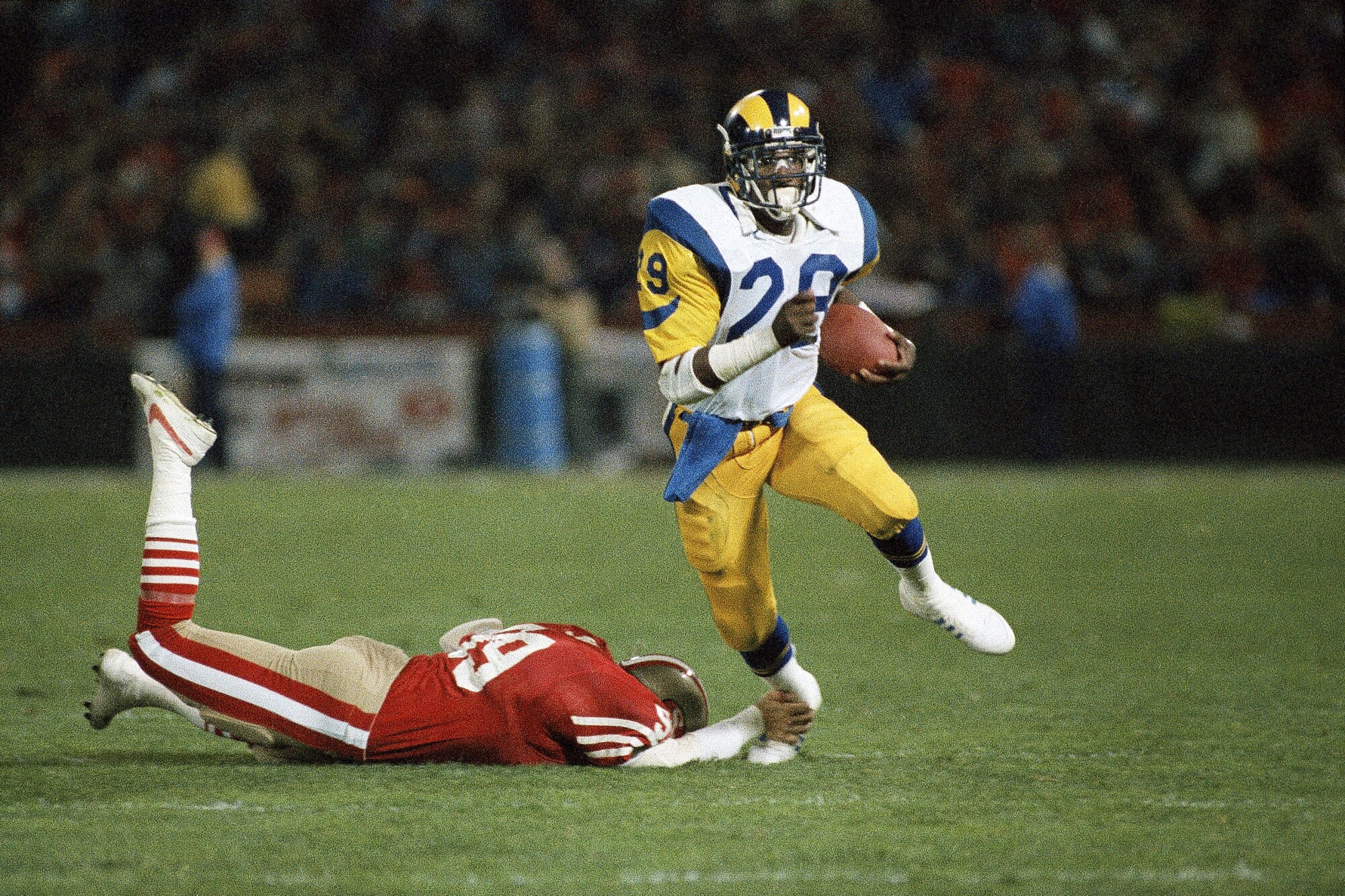 Rams running back Eric Dickerson carries the ball as San Francisco 49ers linebacker Mike Walter tries to tackle him.