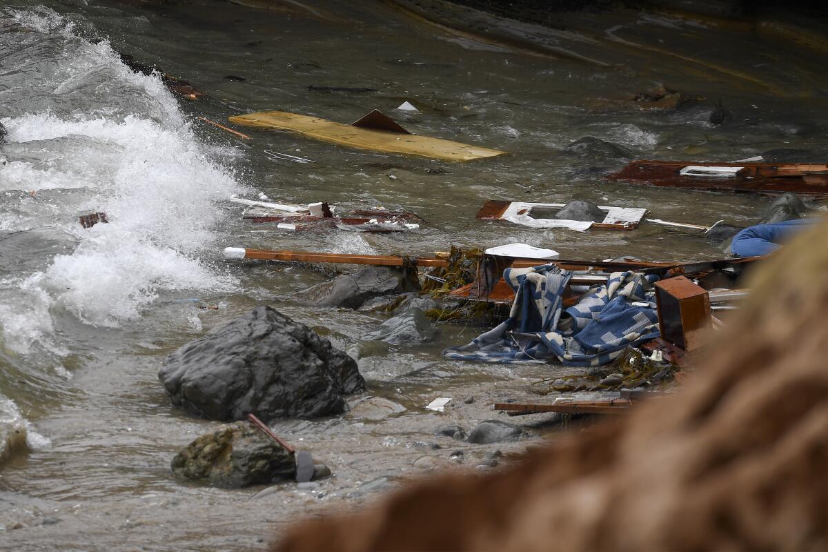 FILE - Wreckage and debris washes ashore at Cabrillo National Monument near where a boat capsized just off the coast on May 2, 2021, in San Diego. A federal judge sentenced a San Diego man to 18 years in prison Friday, Aug. 12, 2022, for piloting a small vessel overloaded with 32 migrants that smashed apart in powerful surf off San Diego's coast last year, killing three people. U.S. District Judge Janis L. Sammartino called it "the most egregious case I've ever had in my courtroom in over 15 years in the Southern District of California" before sentencing 40-year-old Antonio Hurtado. (AP Photo/Denis Poroy, File)