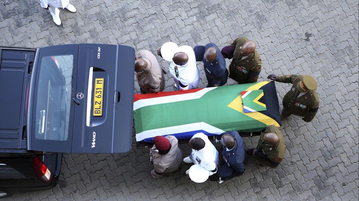 The flag-draped casket of South African liberation fighter Winnie Madikizela-Mandela arrives at the Orlando Stadium in Soweto for her funeral Saturday.