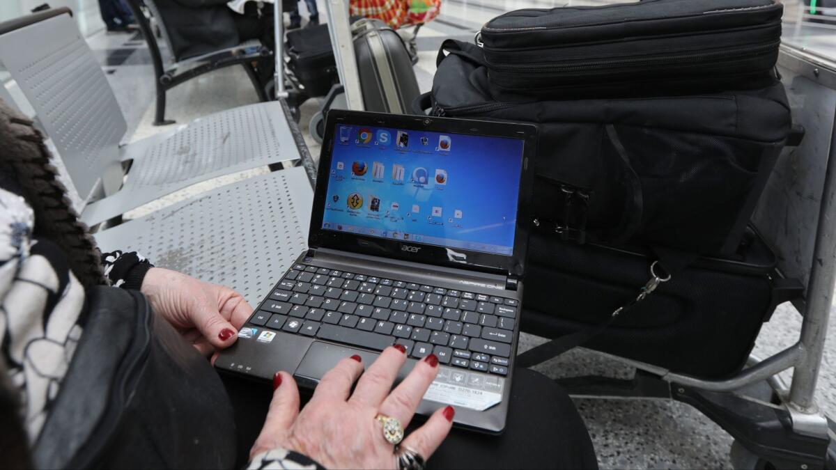 A Syrian woman traveling to the U.S. through Amman opens her laptop in Beirut on March 22.