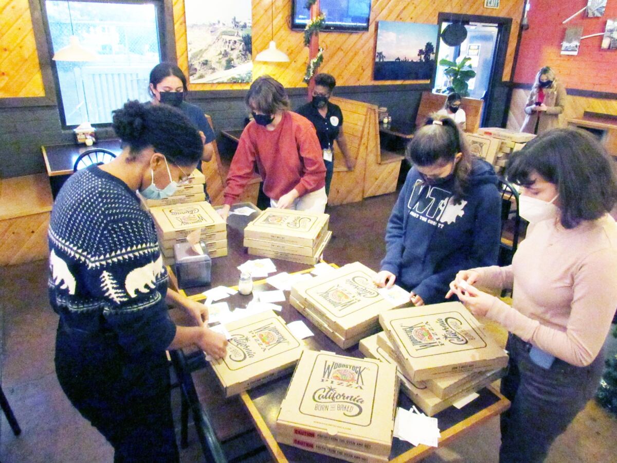 Members of Mission Bay High School Youth Advocates applying stickers on pizza boxes to discourage underage drinking.
