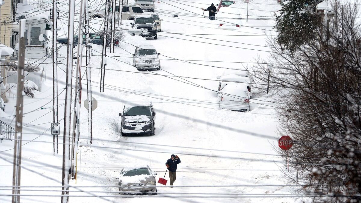Residents on East 24th Street in Erie, Pa., dig out from the snow after a record two-day snowfall.
