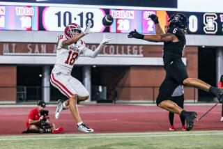 Koen Parnell of Mater Dei catches a 26-yard touchdown pass as Servite's Brandon Mosqueda can't reach ball.