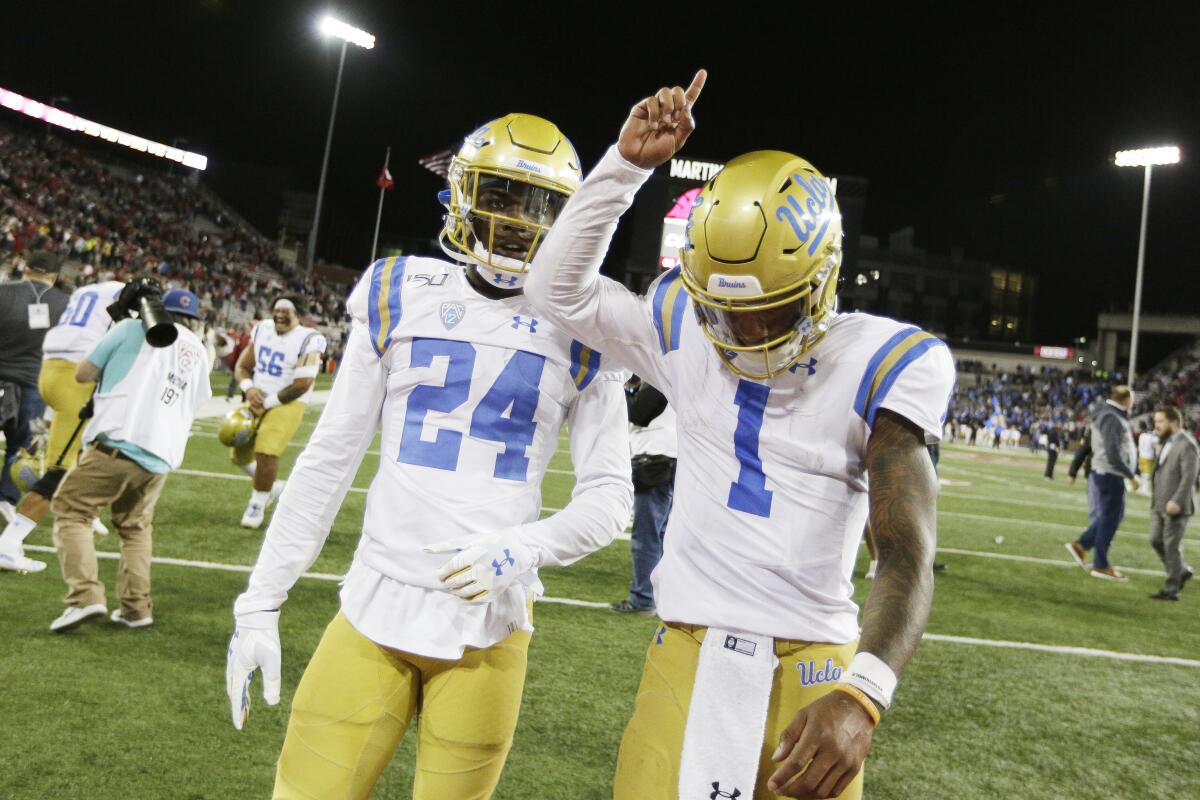 UCLA quarterback Dorian Thompson-Robinson (1) celebrates alongside defensive back Jay Shaw (24) after coming back to beat Washington State.