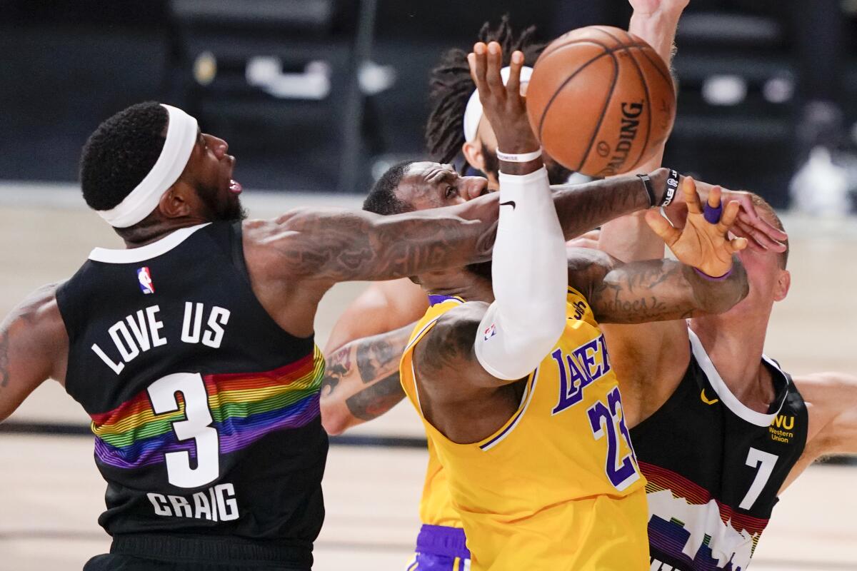Lakers forward LeBron James draws a crowd of Nuggets defenders during a drive in Game 4.