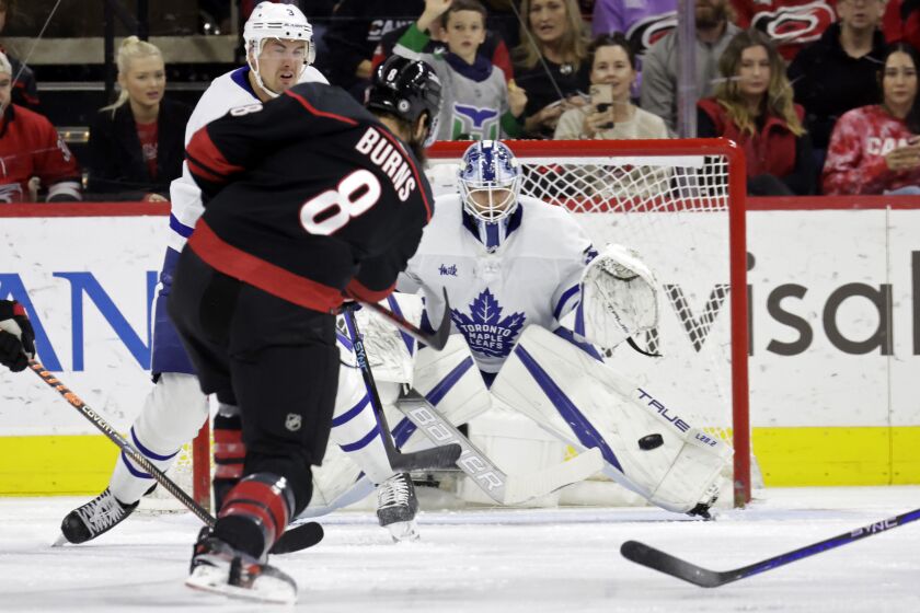 Carolina Hurricanes defenseman Brent Burns (8) fires the puck past Toronto Maple Leafs defenseman Justin Holl, left, and goaltender Matt Murray, right, for a goal during the first period during an NHL hockey game Saturday, March 25, 2023, in Raleigh, N.C. (AP Photo/Chris Seward)