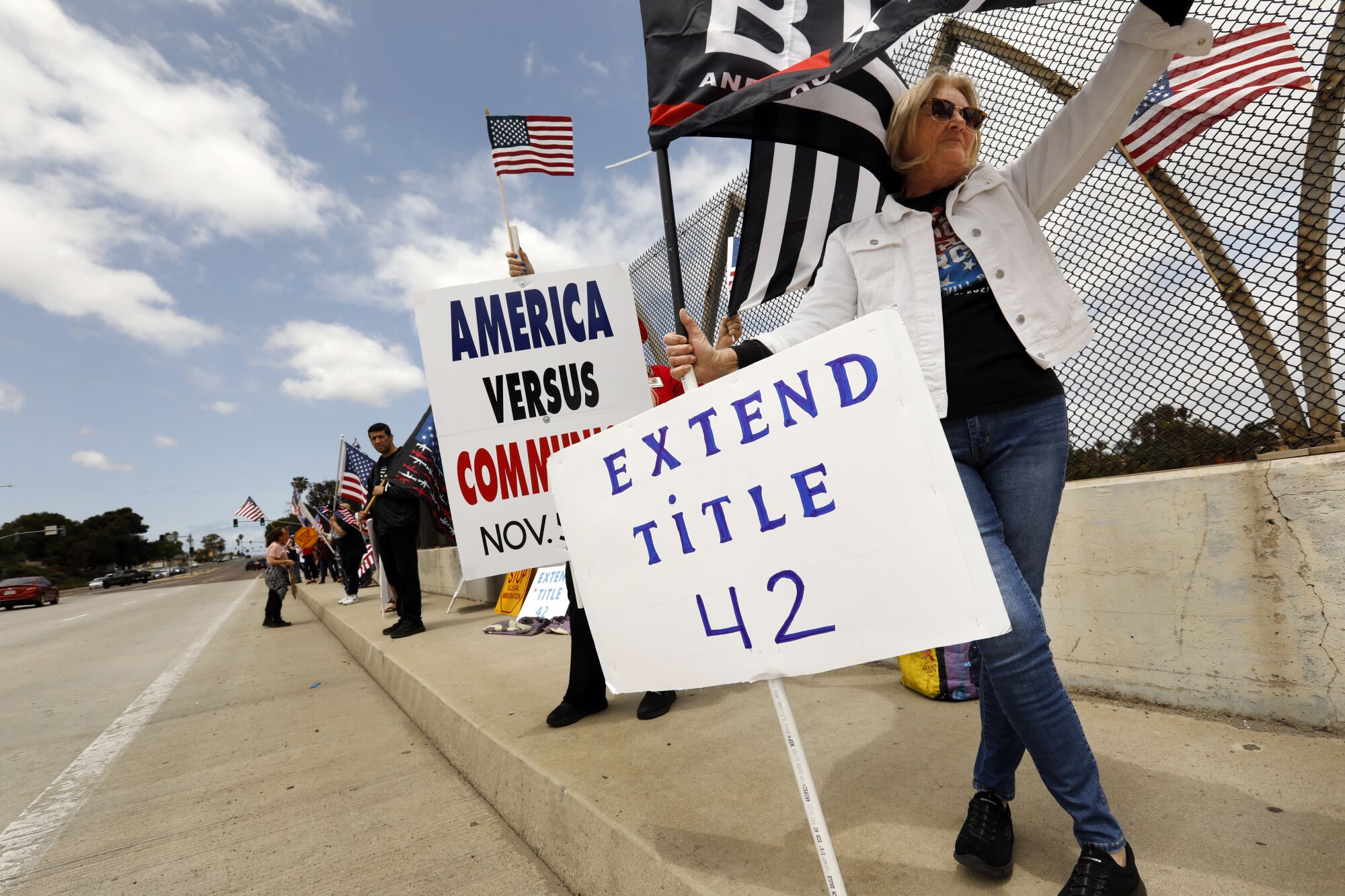 İnsanlar Kaliforniya, Chula Vista'daki bir miting sırasında Başlık 42'nin uzatılmasını destekleyen tabelalar taşıyor.